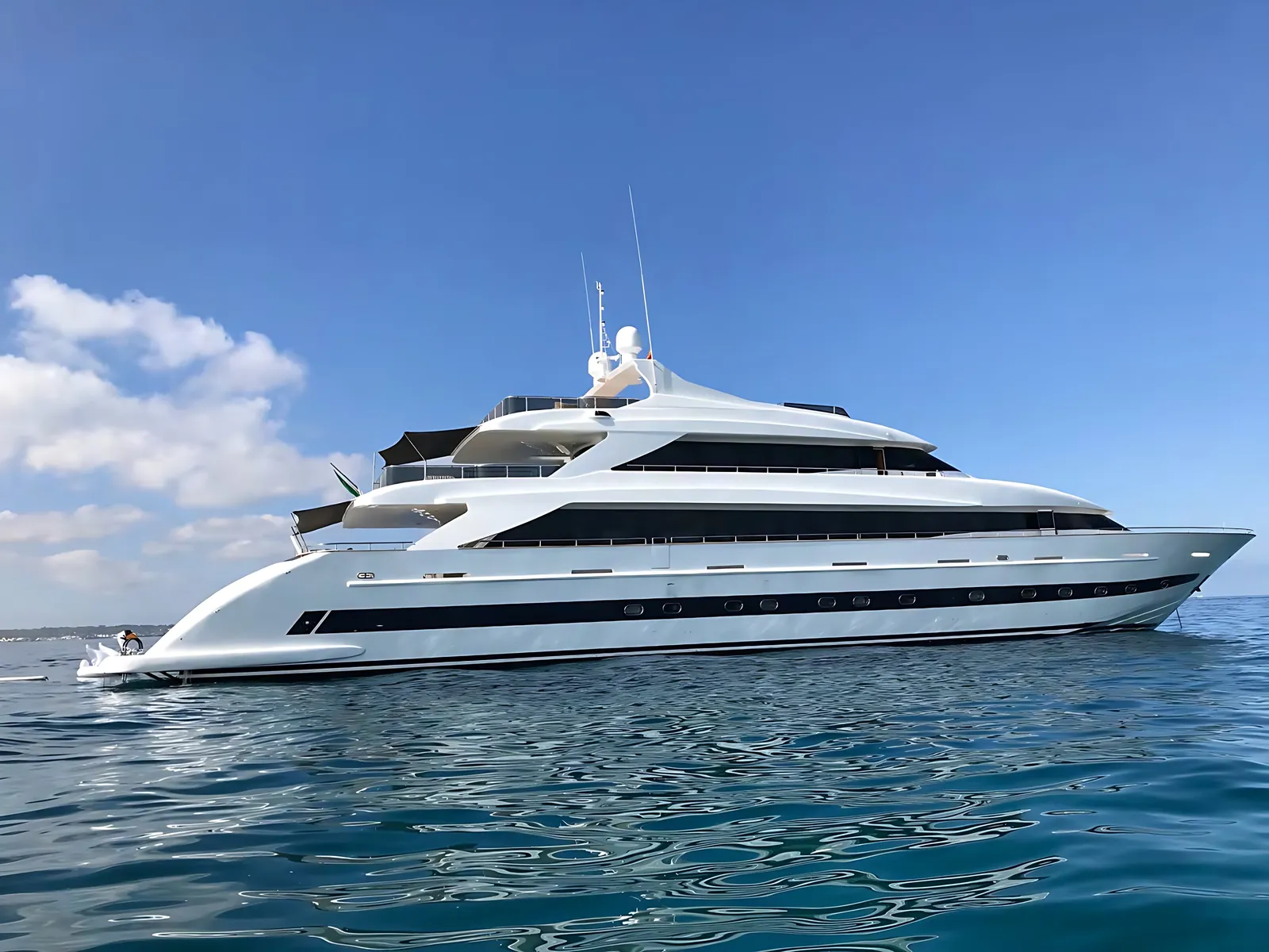 Admiral 44 superyacht at anchor in calm open water under a blue sky with light cloud